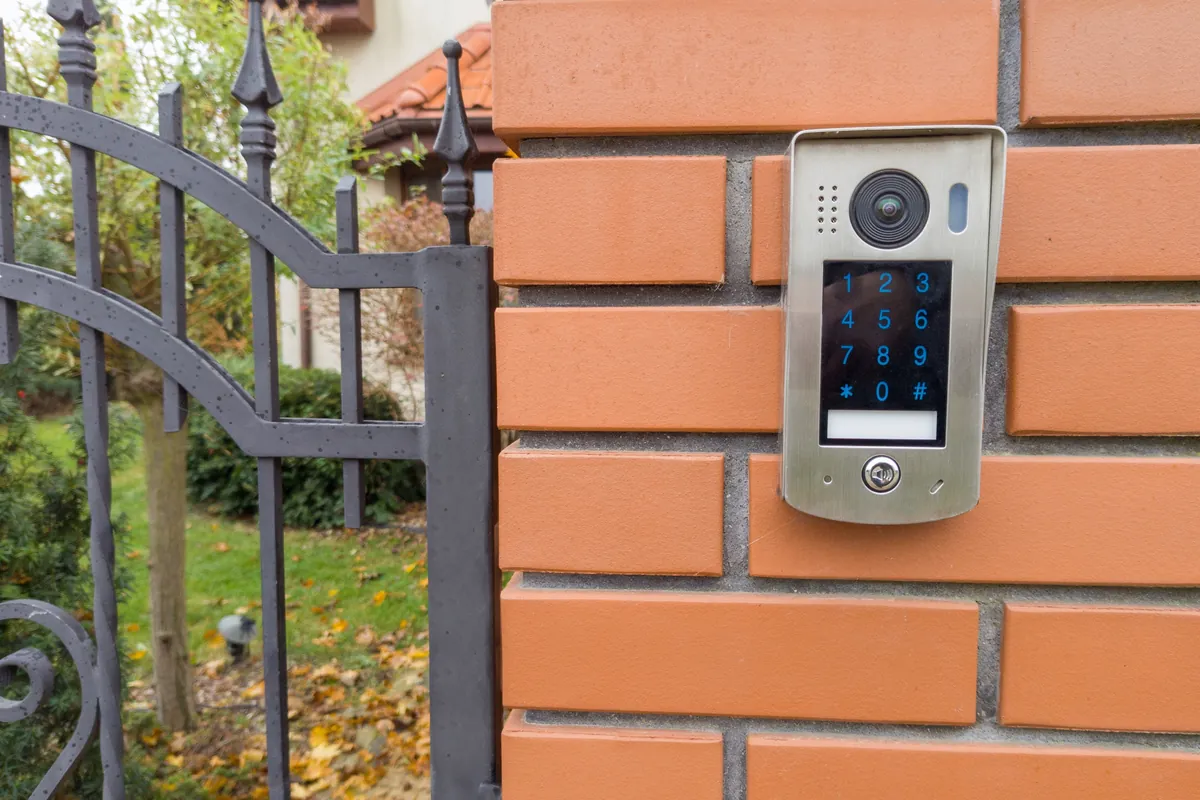 Kódos videós kaputelefon a kerítés téglaoszlopán