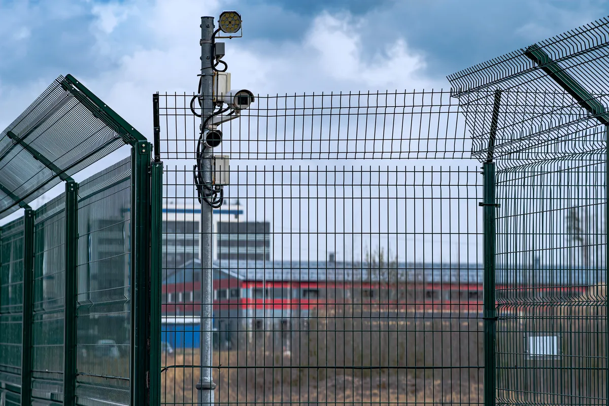 Kamerák egy telephely kerítése melletti oszlopon